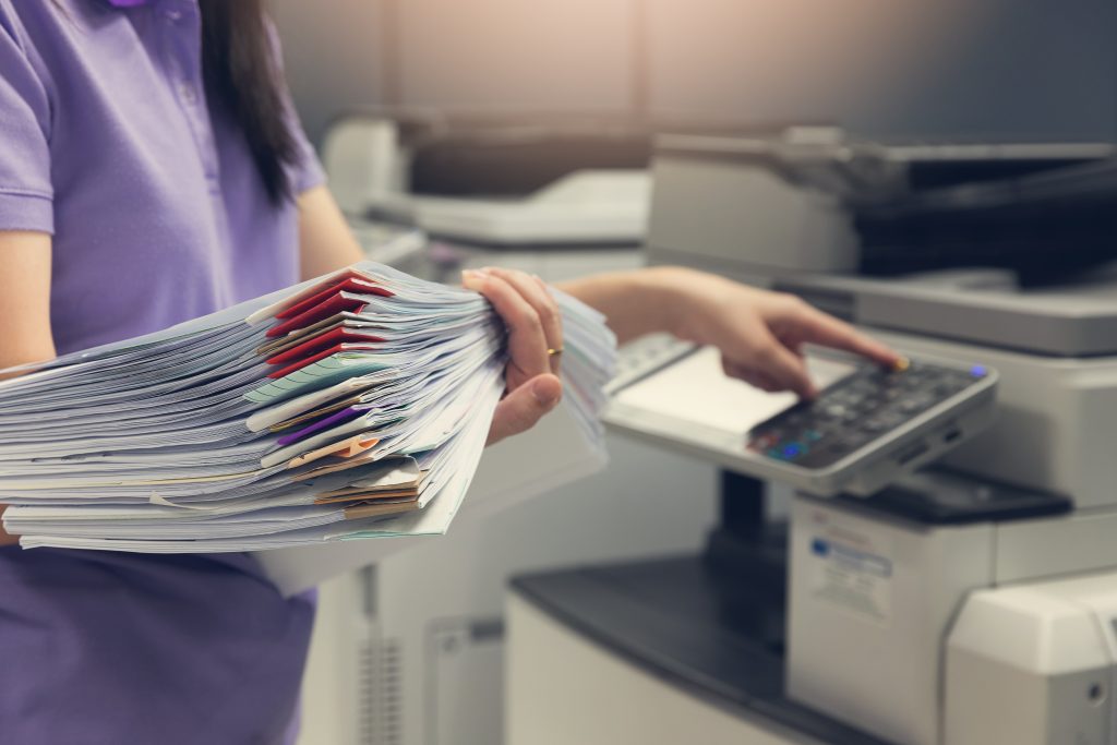 Business woman carrying stack of documents